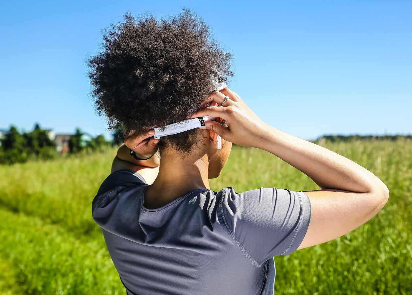 Curly Hair Female Athlete adjusting her hat from run